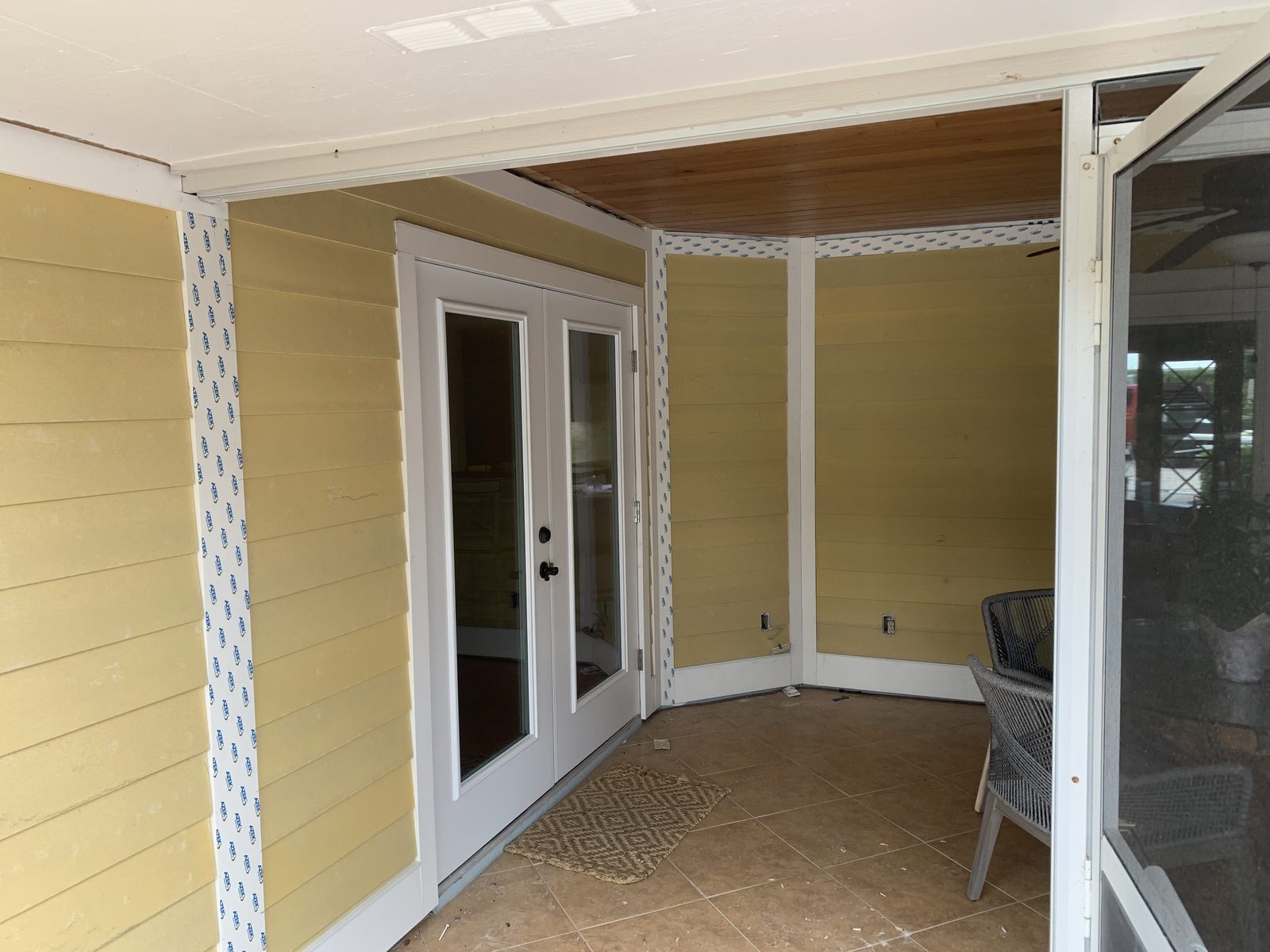 Lanai walls clad in lap siding with new french doors installed