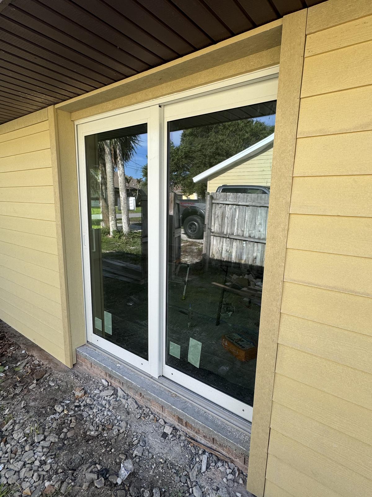 New sliding glass door set into a freshly sided exterior wall
