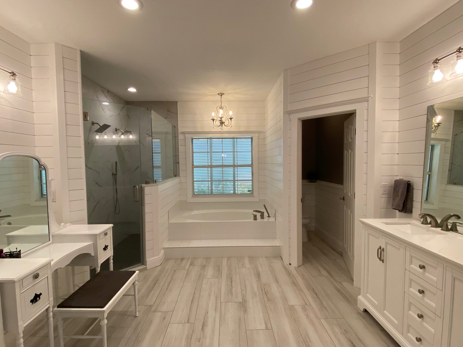 Primary bathroom finished in shiplap with a tile shower and soaking tub