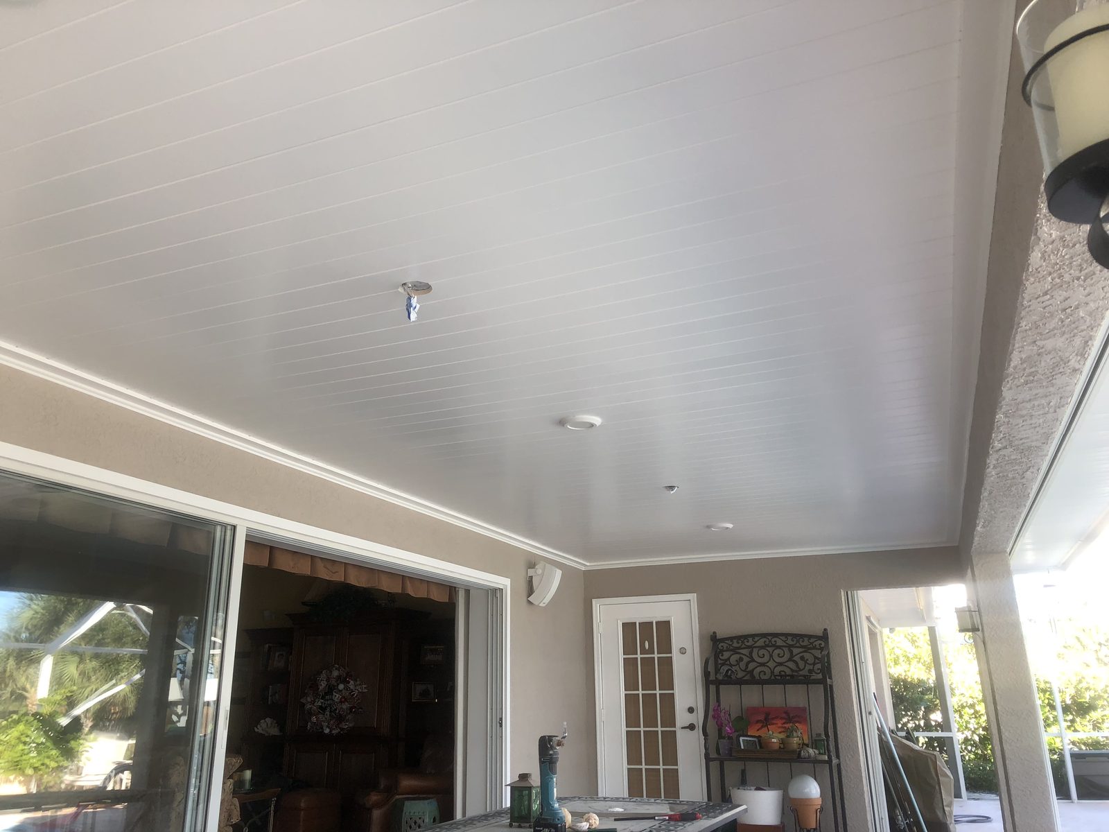 White beadboard ceiling finished across a screened lanai