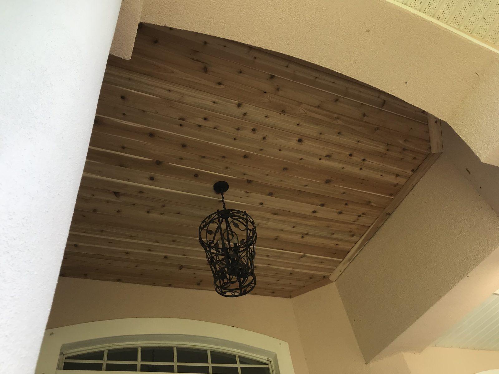 Cedar plank entry ceiling with an iron lantern pendant