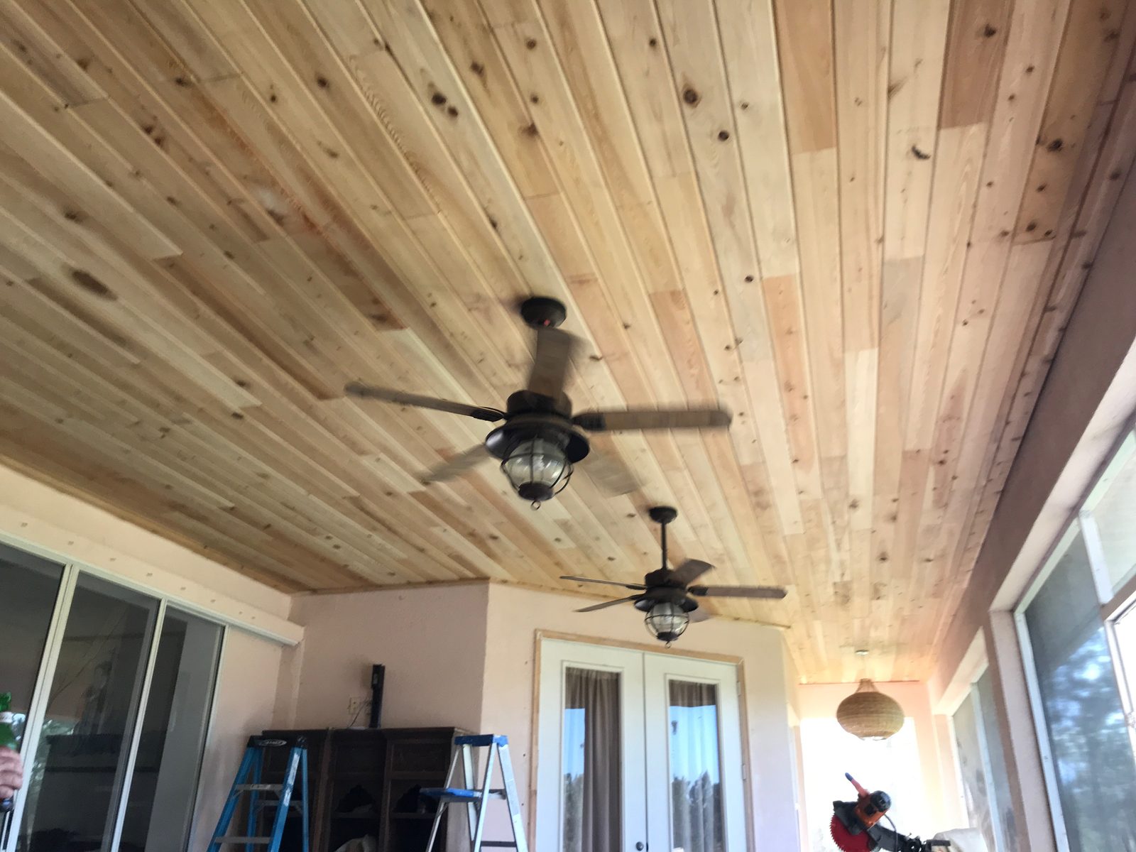 Cedar plank lanai ceiling with two hanging ceiling fans