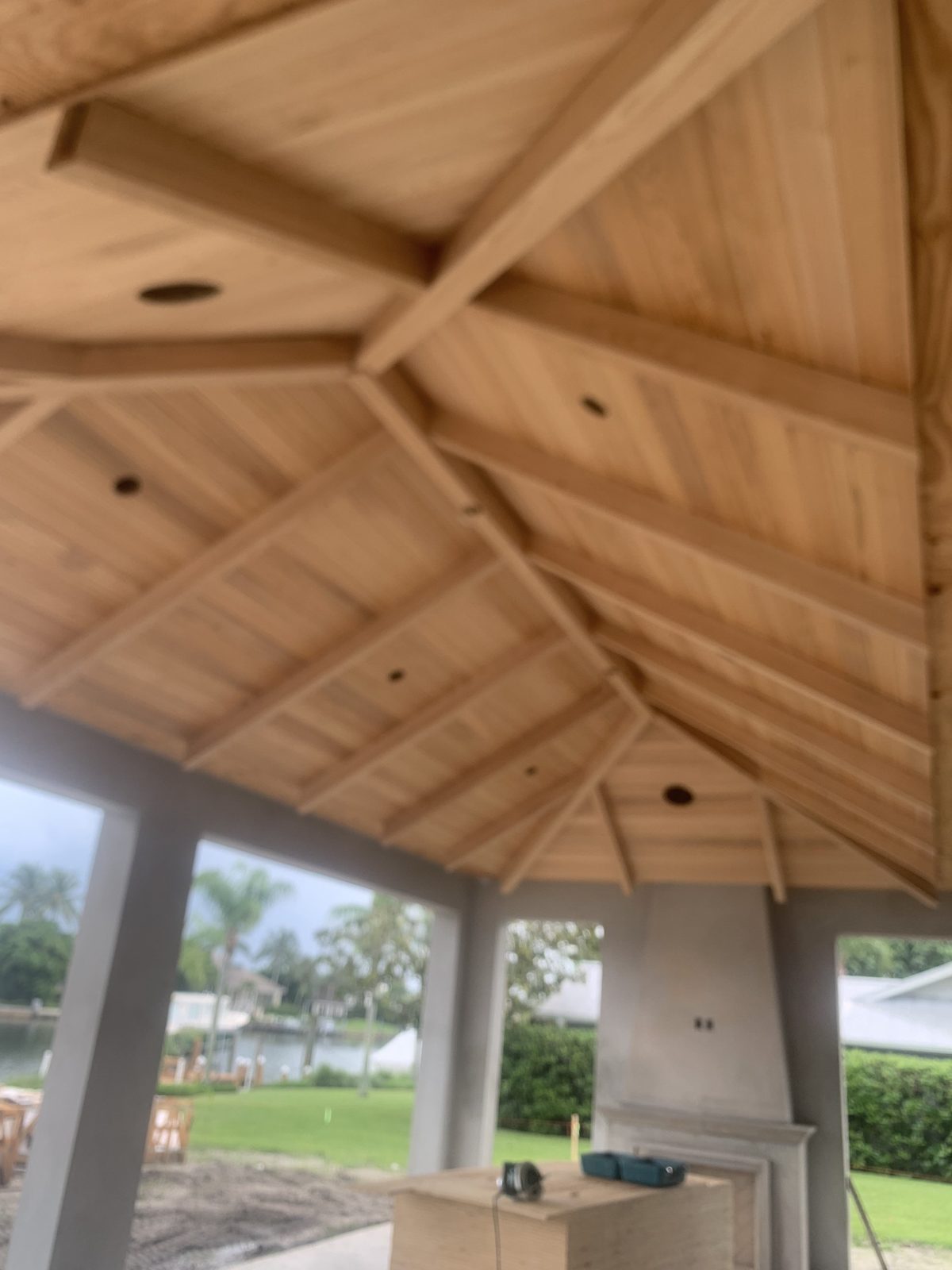 Cypress hip ceiling with exposed rafters over a waterfront outdoor room