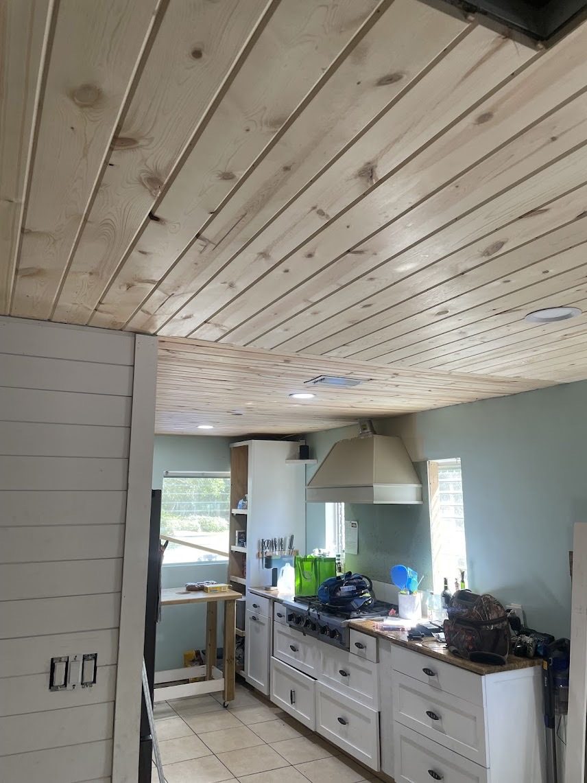 Whitewashed pine plank ceiling installed over a kitchen