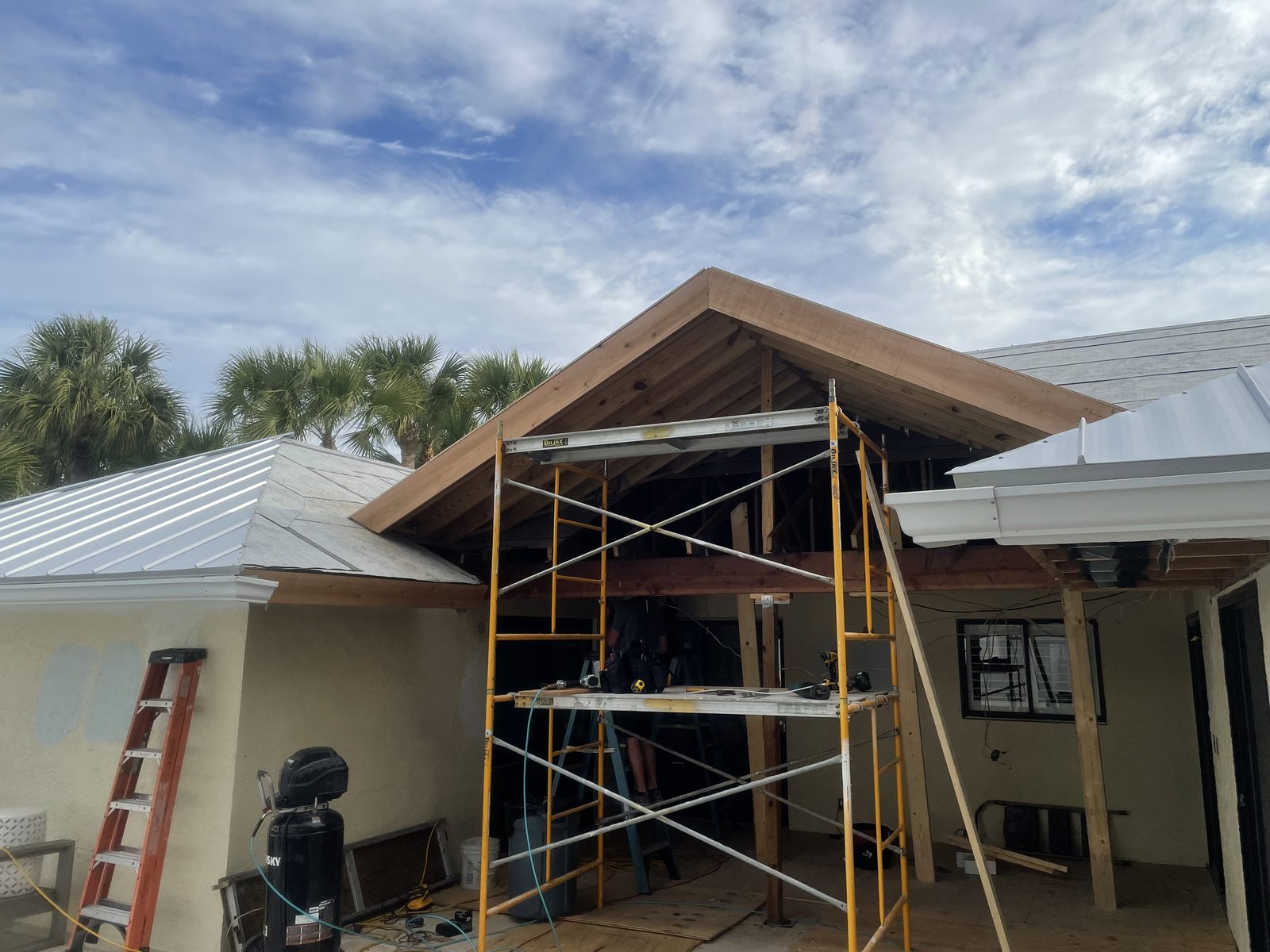 Hip roof structure framed over a pool deck, seen from the roofline