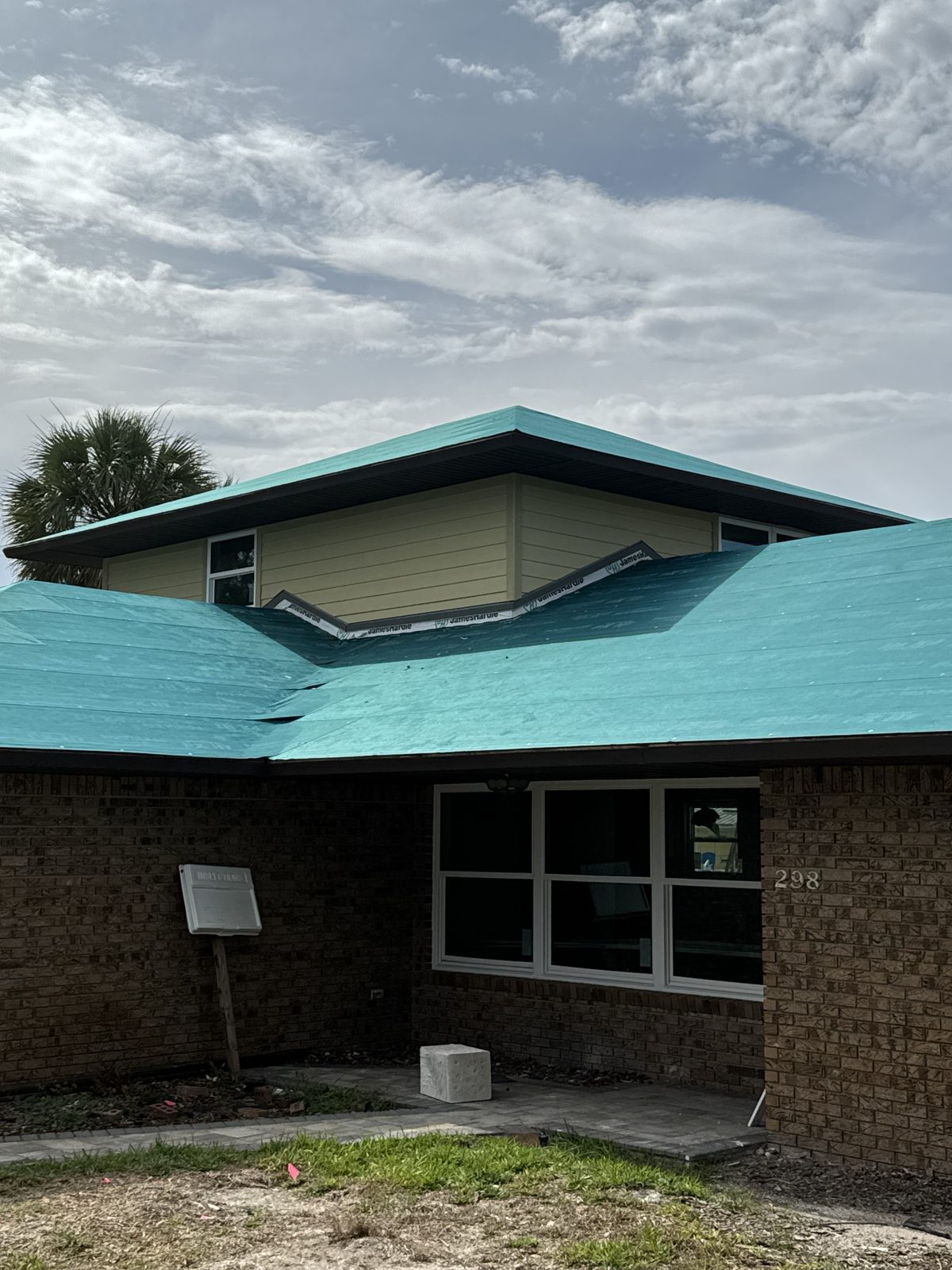 Roof dried in over a brick home with new siding on the upper walls