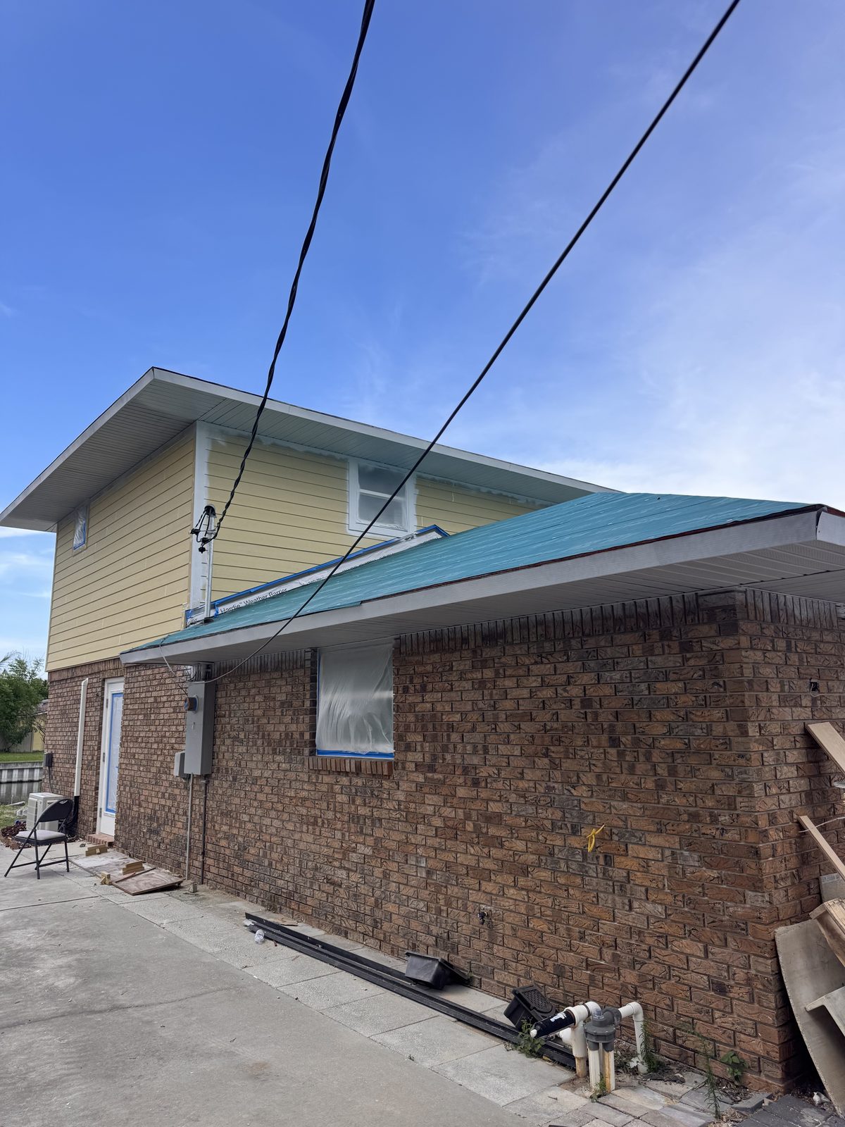Two-story reroof dried in with new lap siding above the brick