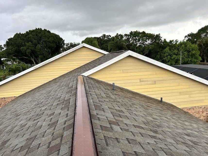 Finished shingle roof running to a clean valley between two gables