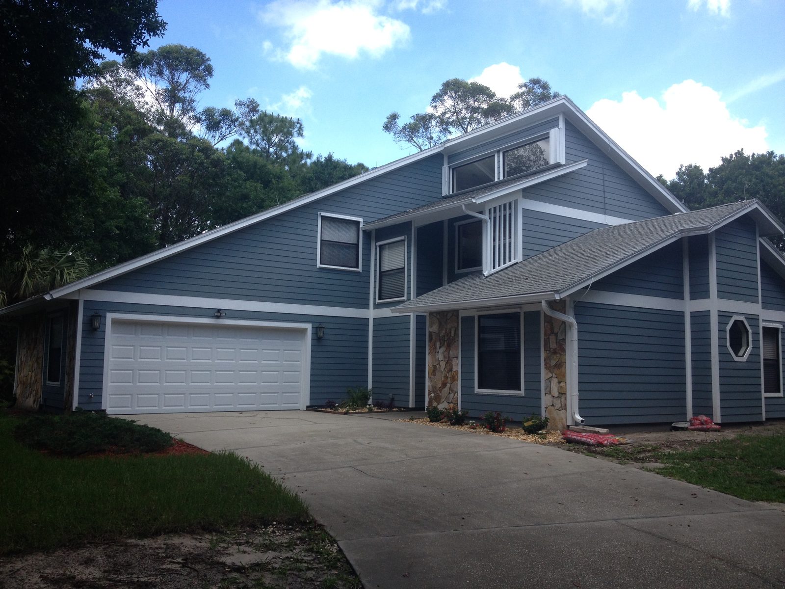 Blue lap siding and white trim across the front of a two-story home