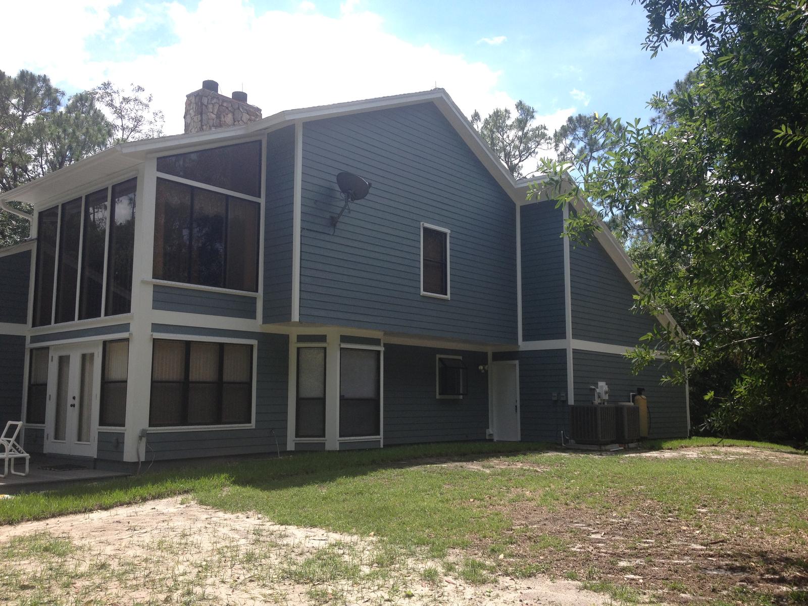 Rear elevation of a home finished in blue lap siding and white trim