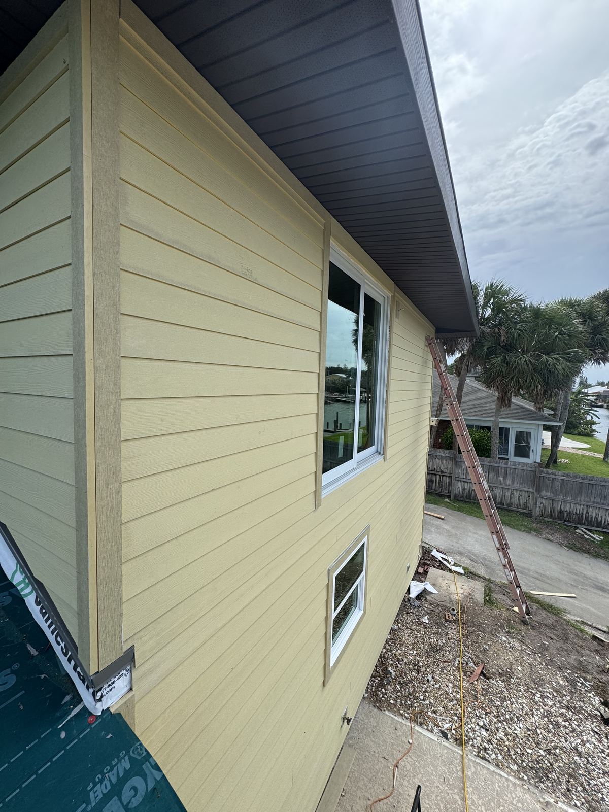 Fiber cement lap siding and corner boards wrapped around a new window