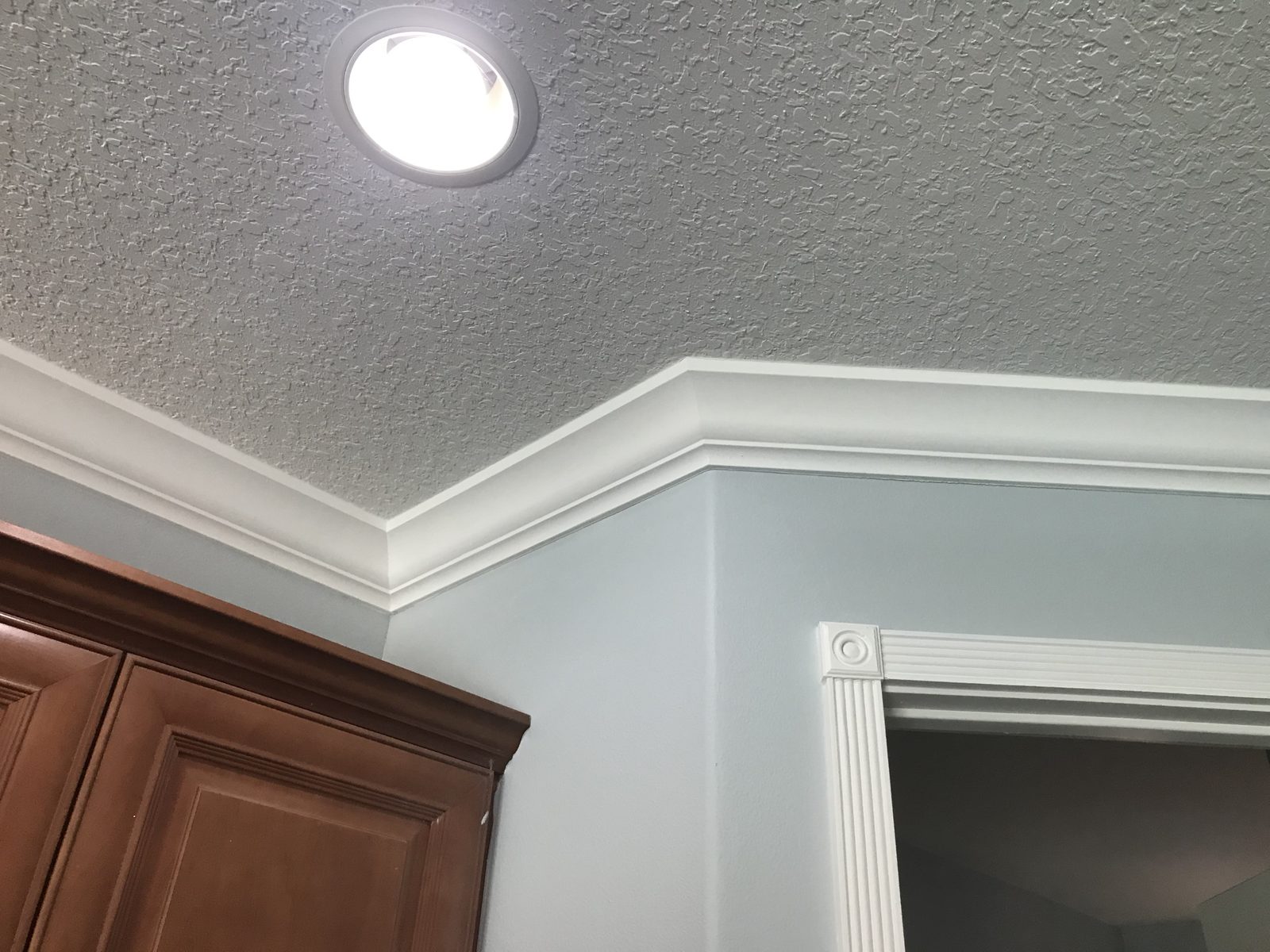 Crown molding meeting fluted door casing with a rosette corner block