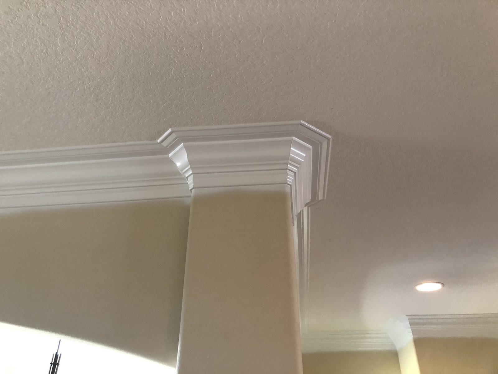 Layered crown molding wrapping a soffit corner with a clean stepped return