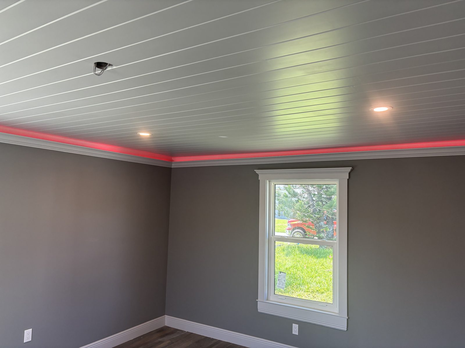 Plank ceiling with crown molding and cove lighting in a finished bedroom