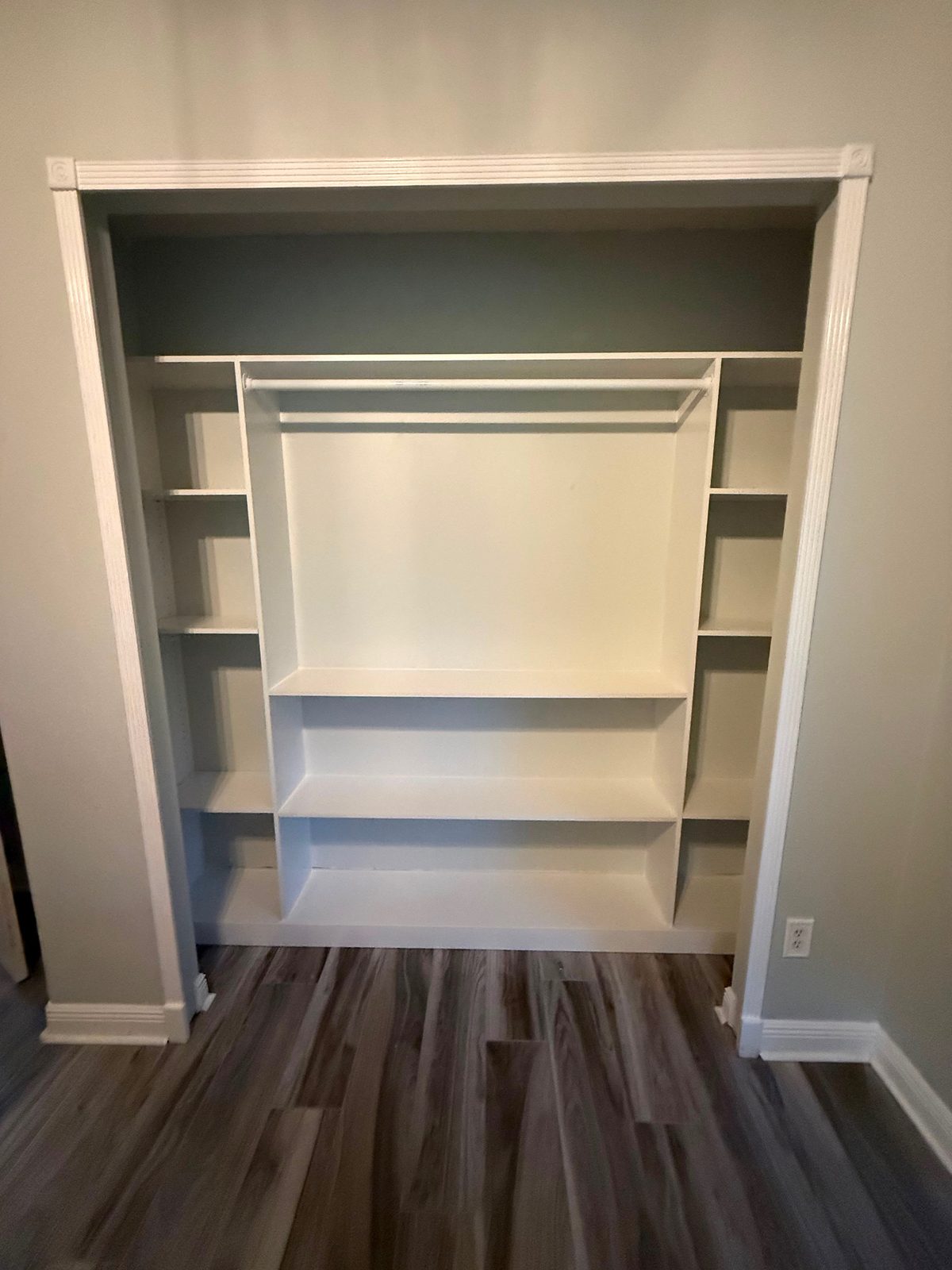 Built-in closet shelving framed with fluted casing and rosette blocks
