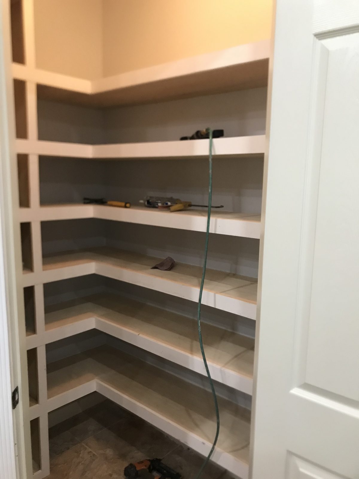 Corner pantry fitted with wrap-around shelving to the ceiling