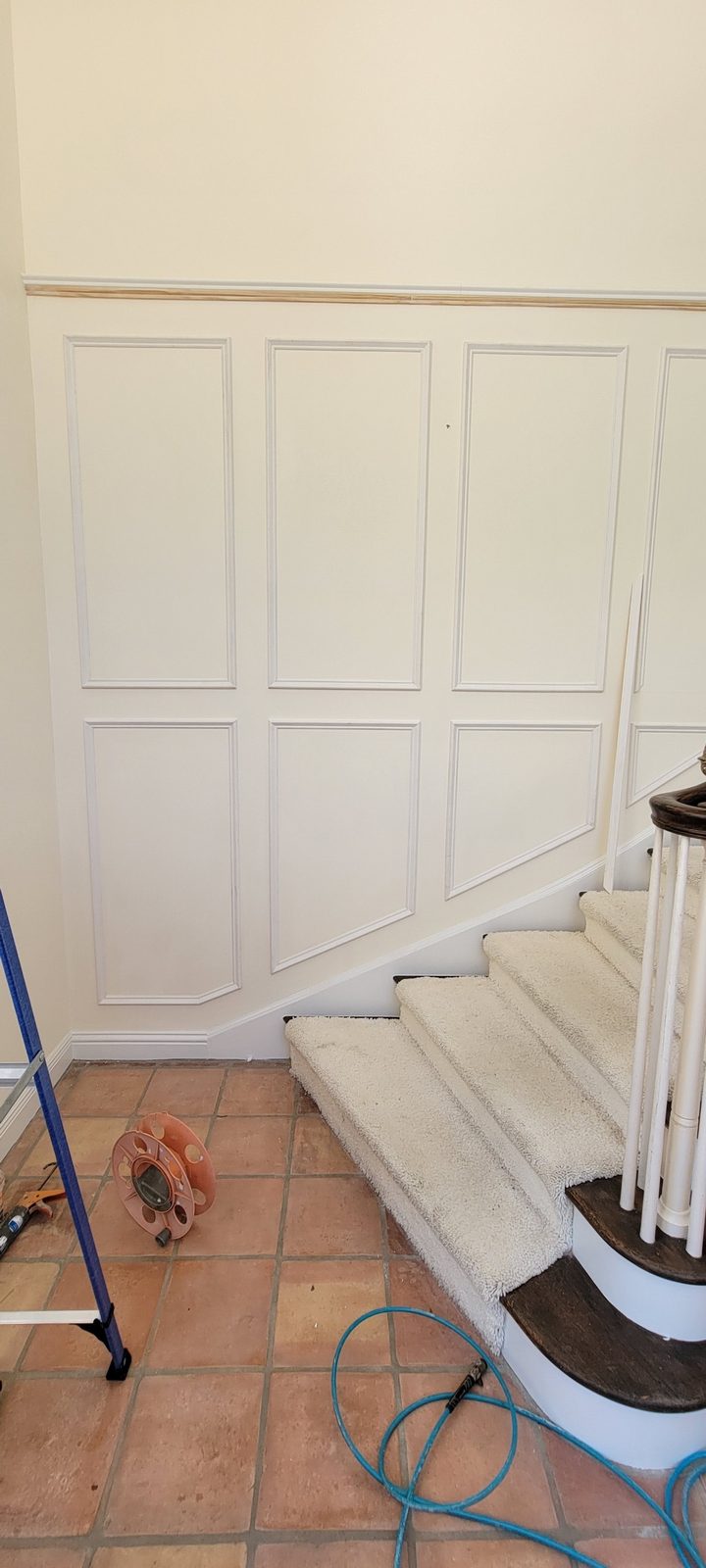 Curved staircase wall finished with custom raised-panel wainscoting