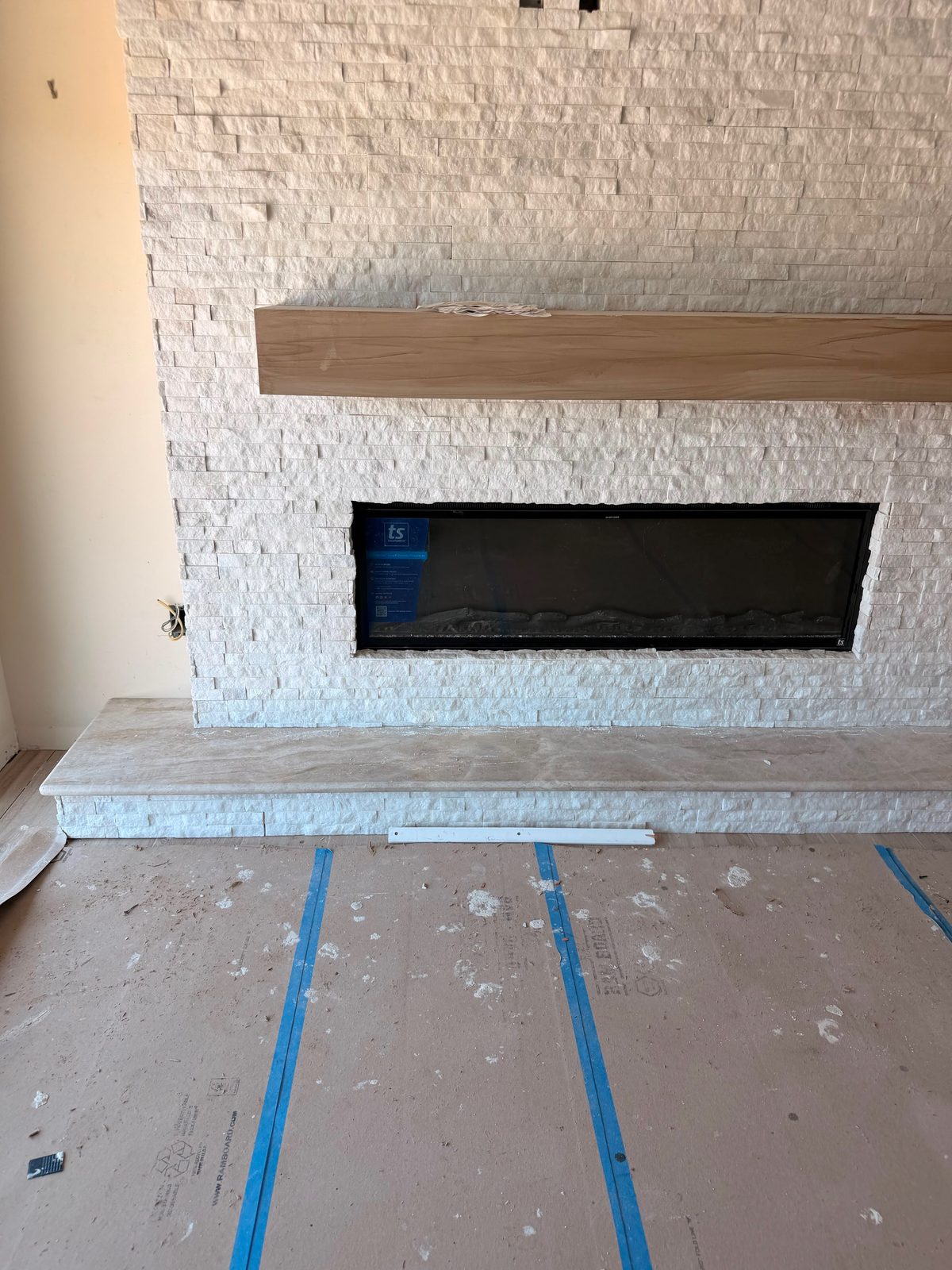 Stacked stone fireplace surround with a solid wood mantel beam